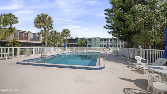 community pool with fence and a patio