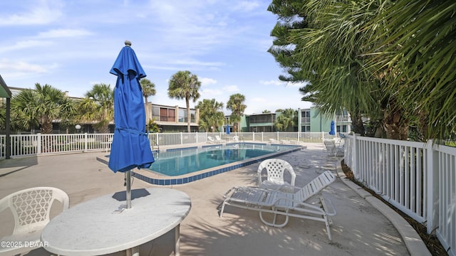 community pool featuring a patio and fence
