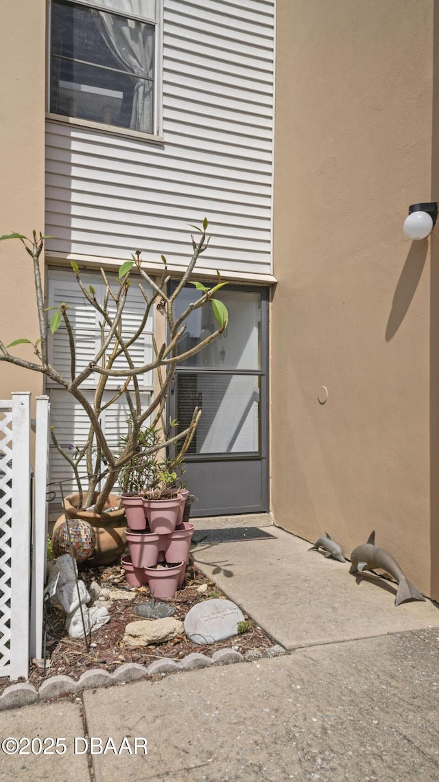 doorway to property featuring stucco siding