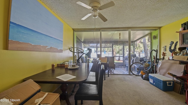 carpeted dining room featuring expansive windows, a textured ceiling, ceiling fan, and a sunroom