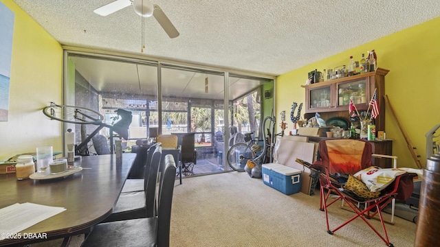 carpeted dining space with a ceiling fan, a textured ceiling, and a wall of windows