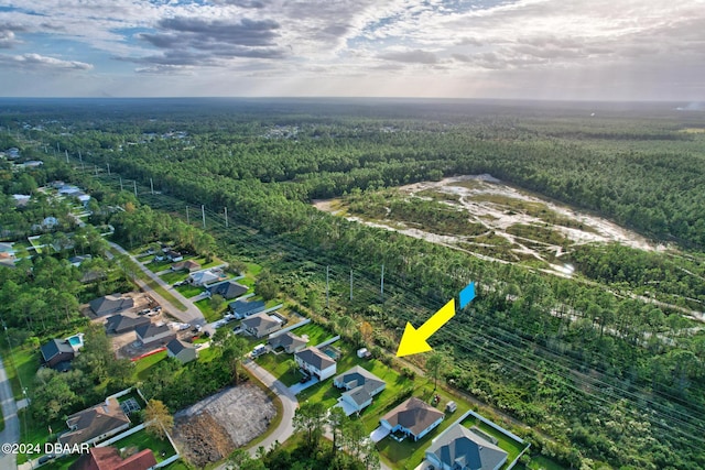 view of property location featuring a heavily wooded area and nearby suburban area