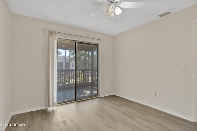 unfurnished room with ceiling fan, wood-type flooring, and a textured ceiling