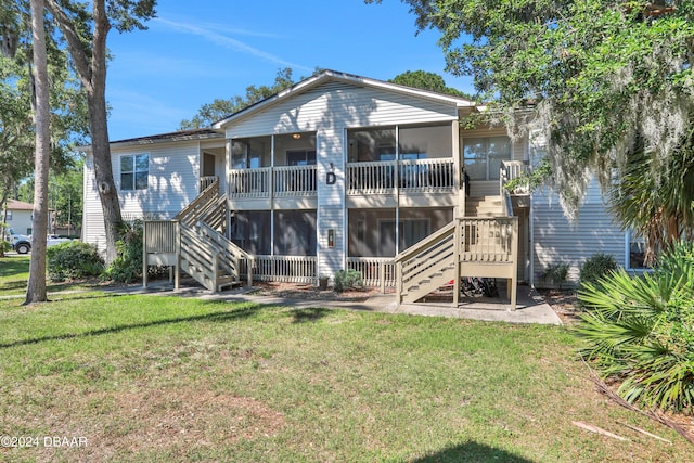 back of house featuring a sunroom and a yard