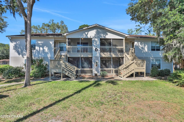 rear view of property with a sunroom and a yard