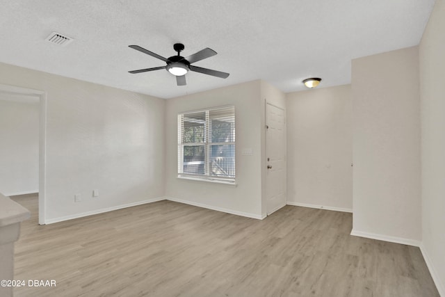 spare room featuring ceiling fan, a textured ceiling, and light hardwood / wood-style flooring