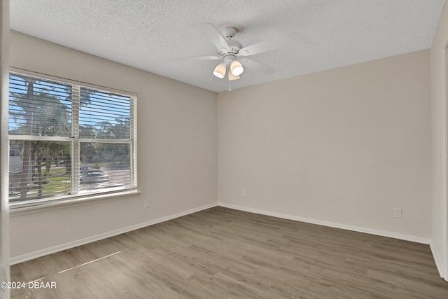 unfurnished room with hardwood / wood-style floors, ceiling fan, and a textured ceiling