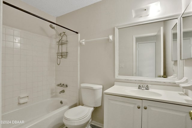 full bathroom featuring vanity, a textured ceiling, toilet, and tiled shower / bath