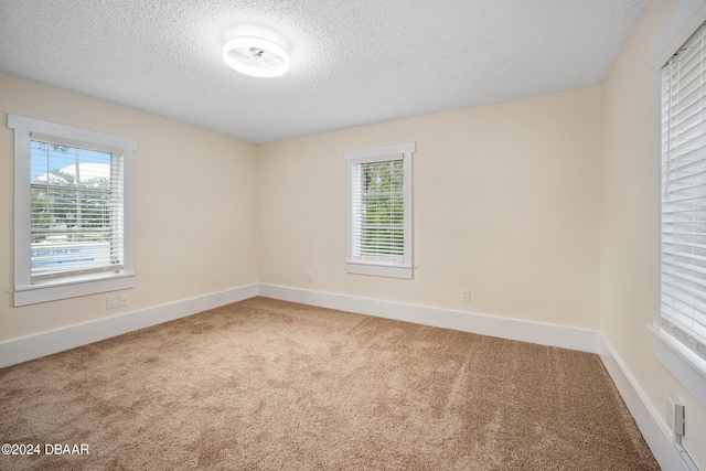 carpeted spare room featuring a textured ceiling