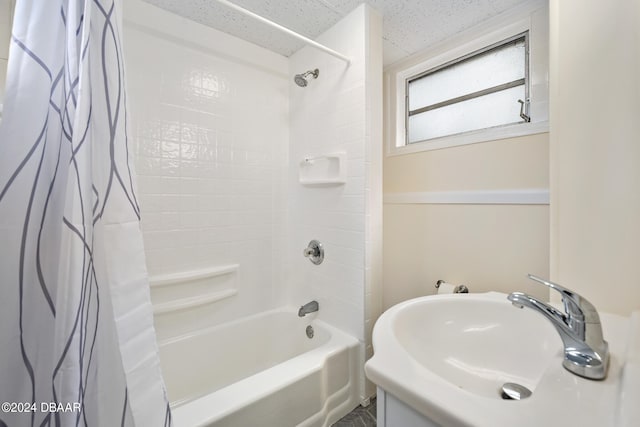 bathroom featuring shower / bath combo with shower curtain, sink, and a textured ceiling