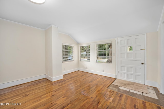 entryway featuring vaulted ceiling, hardwood / wood-style flooring, and crown molding