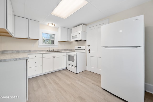 kitchen with white cabinets, light hardwood / wood-style flooring, sink, and white appliances