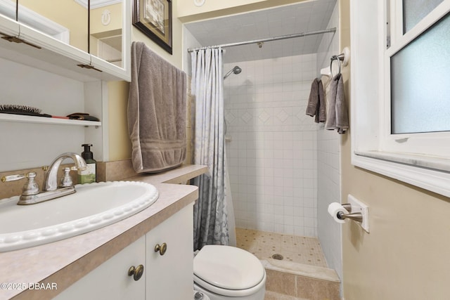 bathroom featuring tiled shower, toilet, and vanity