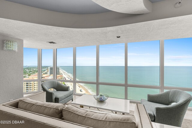 2545 S Atlantic Ave Unit 0102, Daytona Beach Shores, FL 32118 - living room with a water view, a wall of windows, a textured wall, and a textured ceiling