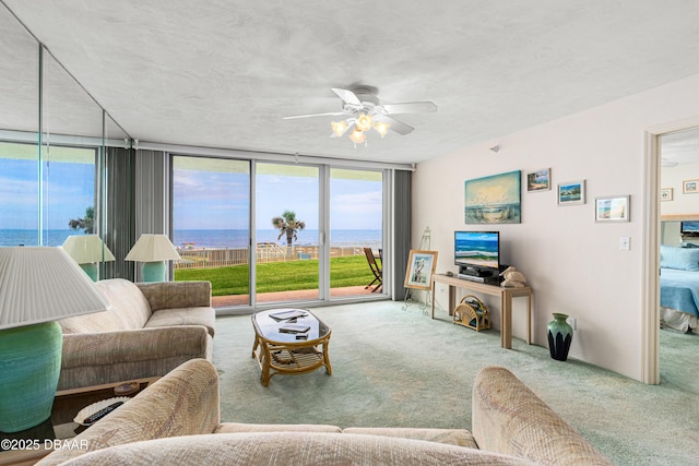2545 S Atlantic Ave Unit 0102, Daytona Beach Shores, FL 32118 - carpeted living room featuring a water view, ceiling fan, and expansive windows