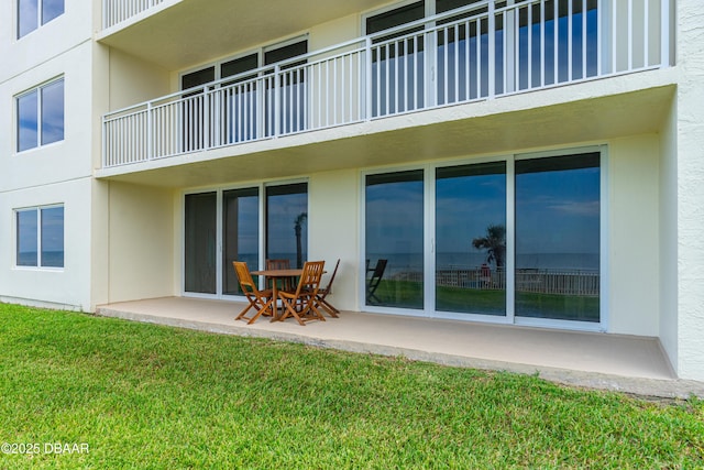 2545 S Atlantic Ave Unit 0102, Daytona Beach Shores, FL 32118 - rear view of house with stucco siding, a lawn, and a patio
