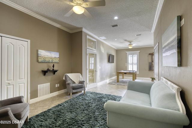 living room featuring crown molding, light tile patterned floors, ceiling fan, and a textured ceiling