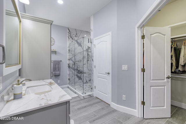 bathroom featuring vanity and a shower with door