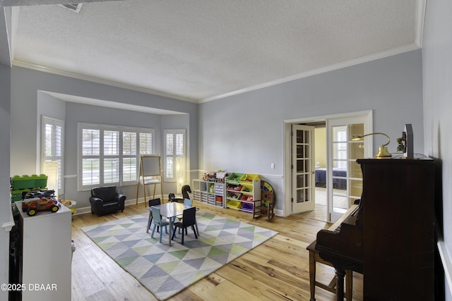 interior space featuring light hardwood / wood-style flooring, ornamental molding, and a textured ceiling