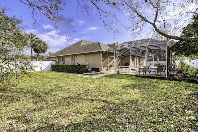 back of property featuring a fenced in pool, a patio area, glass enclosure, and a lawn