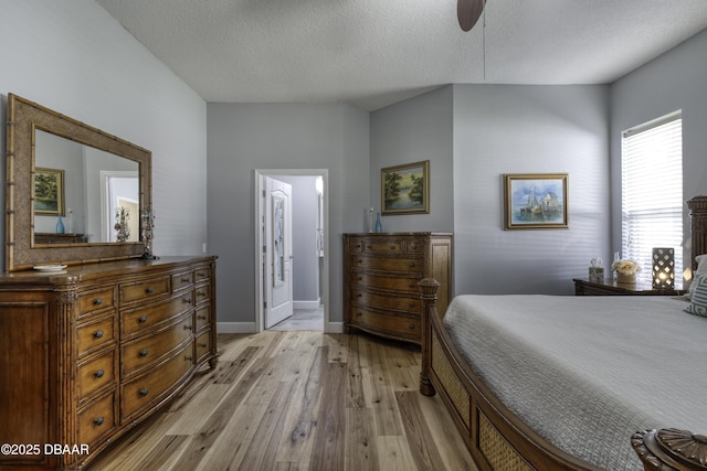 bedroom with a textured ceiling, light hardwood / wood-style floors, and ensuite bath