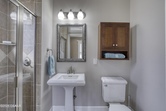 bathroom featuring toilet and a shower with door