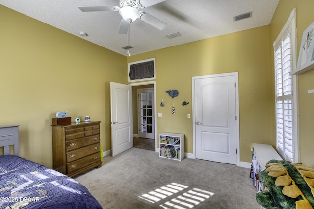 bedroom featuring light carpet, ceiling fan, and a textured ceiling