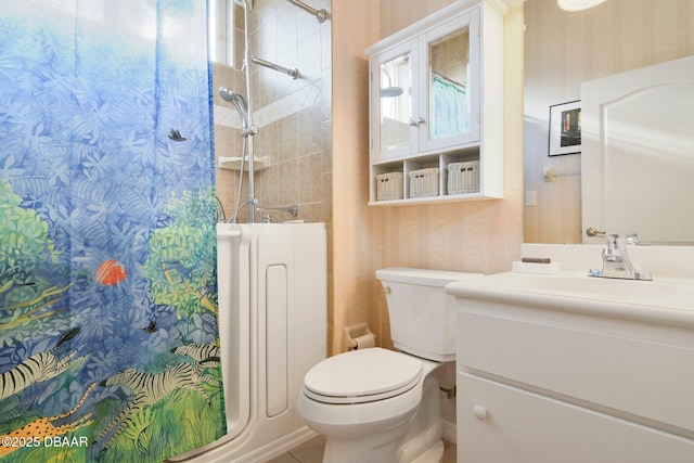 bathroom with tiled shower, vanity, toilet, and radiator