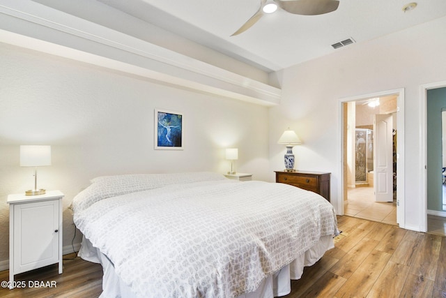 bedroom with ceiling fan, ensuite bath, and hardwood / wood-style floors