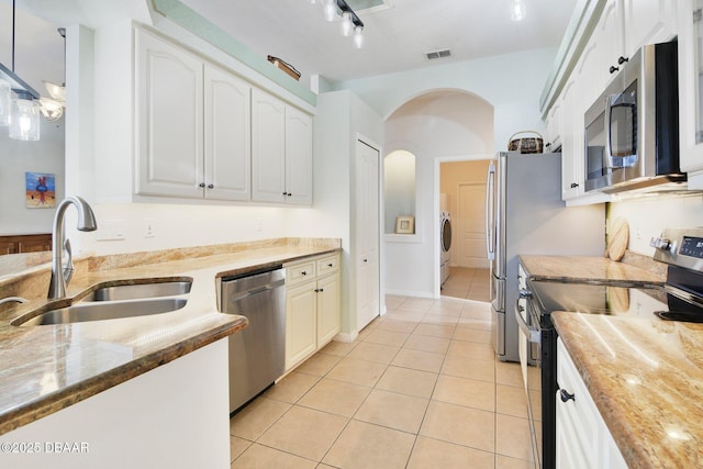 kitchen with sink, hanging light fixtures, stainless steel appliances, light stone countertops, and white cabinets