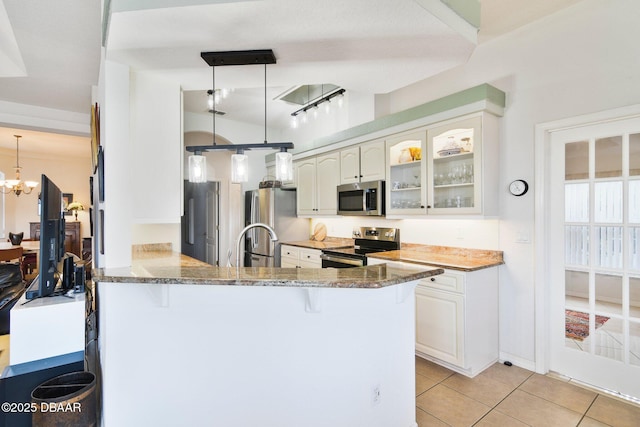 kitchen with white cabinetry, appliances with stainless steel finishes, decorative light fixtures, and kitchen peninsula