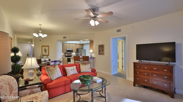 living room featuring ceiling fan with notable chandelier and light tile patterned floors