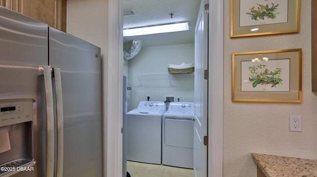 laundry room with a textured ceiling and washer and dryer