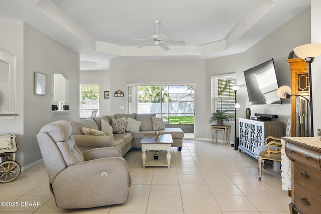 73 Foxhall Ln, Palm Coast, FL 32137 - living room featuring a ceiling fan, a tray ceiling, plenty of natural light, and light tile patterned floors