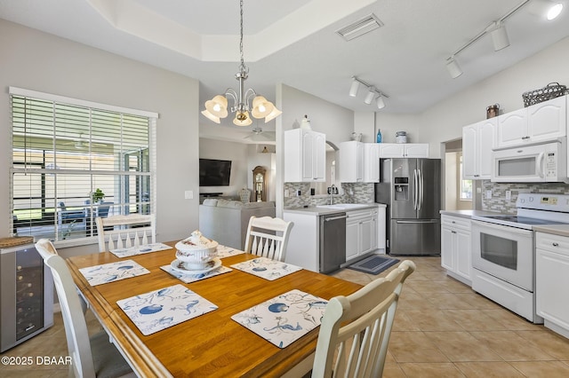 73 Foxhall Ln, Palm Coast, FL 32137 - dining area featuring a chandelier, healthy amount of natural light, light tile patterned flooring, and rail lighting