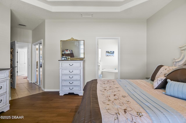 73 Foxhall Ln, Palm Coast, FL 32137 - bedroom with dark wood-style flooring, ensuite bath, and baseboards
