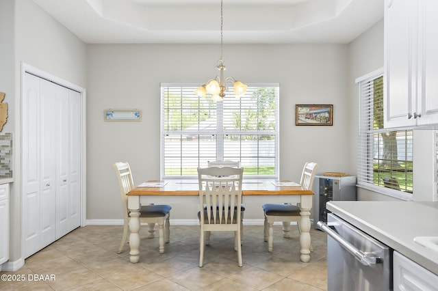 73 Foxhall Ln, Palm Coast, FL 32137 - dining area featuring a chandelier, a raised ceiling, light tile patterned floors, and baseboards
