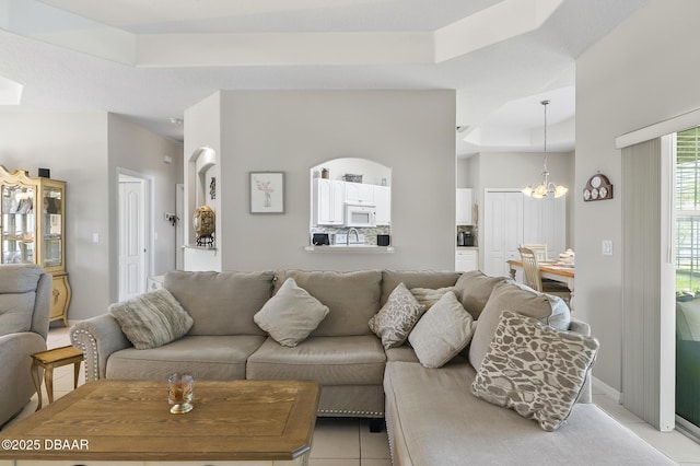 73 Foxhall Ln, Palm Coast, FL 32137 - living room with a tray ceiling, a chandelier, and light tile patterned floors