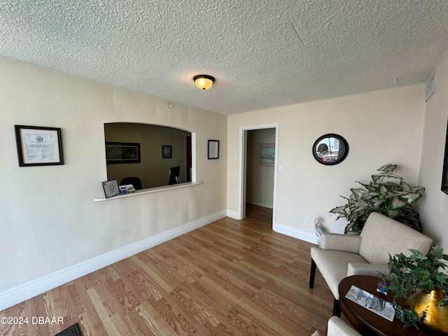 unfurnished room with hardwood / wood-style floors and a textured ceiling