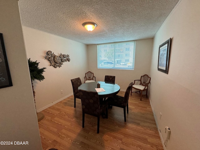 dining room featuring hardwood / wood-style floors and a textured ceiling