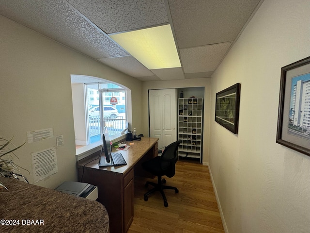 office area with wood-type flooring and a drop ceiling