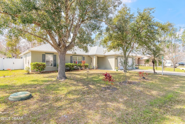 ranch-style house with stucco siding, an attached garage, fence, driveway, and a front lawn