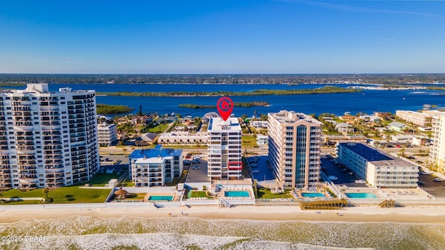 birds eye view of property with a water view and a beach view