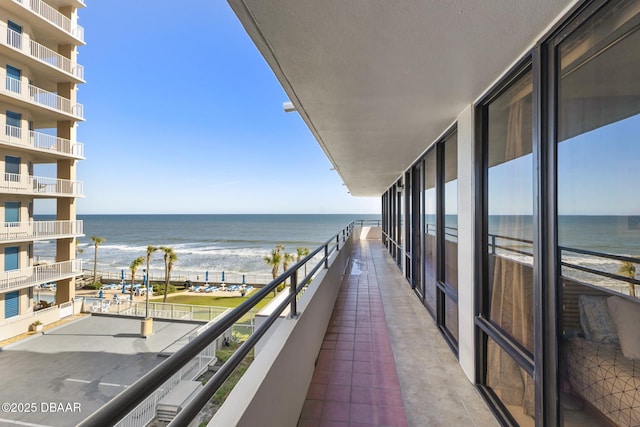 balcony featuring a water view and a view of the beach