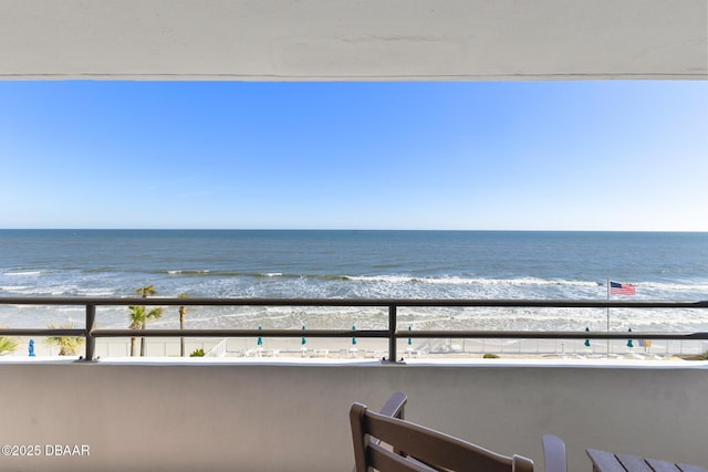 balcony with a water view and a beach view