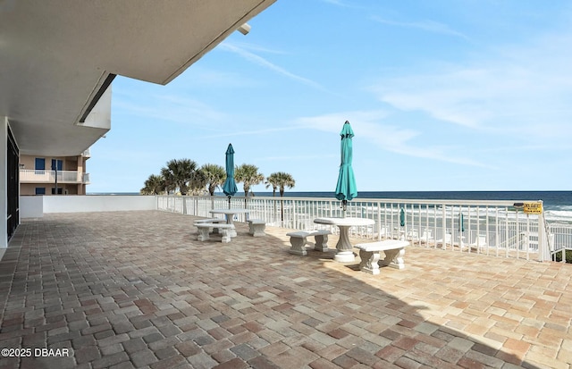 view of patio / terrace with a view of the beach and a water view