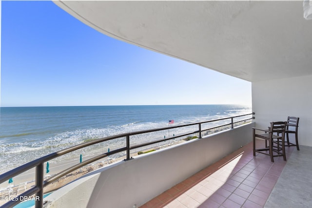 balcony featuring a beach view and a water view