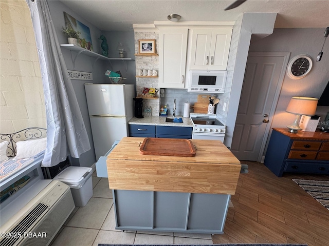 1233 S Atlantic Ave Unit 3070, Daytona Beach, FL 32118 - kitchen featuring white appliances, open shelves, white cabinets, butcher block countertops, and decorative backsplash