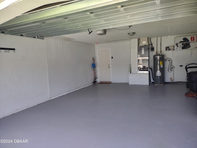 garage with concrete block wall, a garage door opener, and water heater