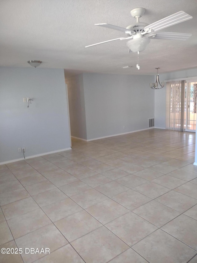 unfurnished room featuring light tile patterned floors, ceiling fan with notable chandelier, visible vents, and a textured ceiling